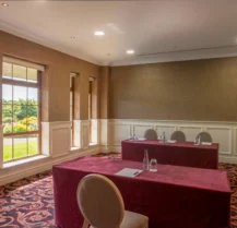 Cosy hotel meeting room with natural light and garden views.