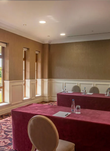 Cosy hotel meeting room with natural light and garden views.