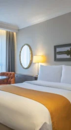 Cosy hotel room with double bed, seating area, and scenic window view.