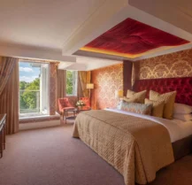 Elegant hotel room with king-sized bed and scenic window view.
