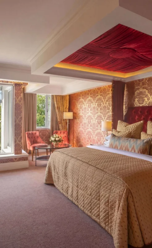 Elegant hotel room with king-sized bed and scenic window view.