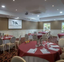 Elegant hotel conference room with round tables, set for a meeting.