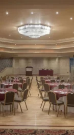 Elegant banquet hall in Hotel Kilmore set for an event, with round tables and red decor.