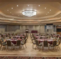 Elegant banquet hall in Hotel Kilmore set for an event, with round tables and red decor.