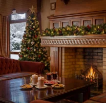 Festive hotel lounge with cosy fireplace and Christmas tree, family enjoying hot drinks.