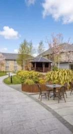 A charming hotel courtyard with cherry blossoms and outdoor seating on a sunny day.