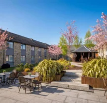 A peaceful courtyard at Hotel Kilmore with tables, chairs, and blossoming trees.