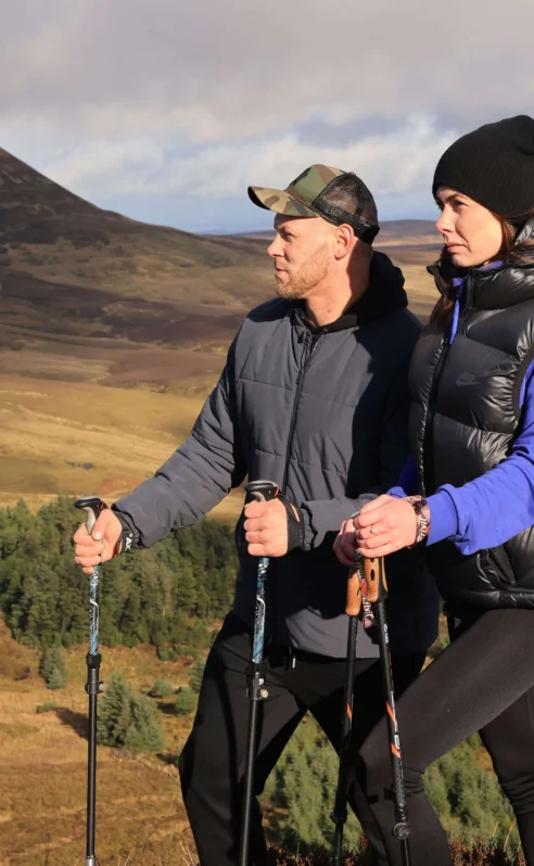 A couple hikes through scenic hills near Hotel Kilmore, enjoying outdoor adventure.