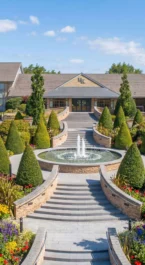 Grand entrance of Hotel Kilmore with lush gardens and a central fountain.