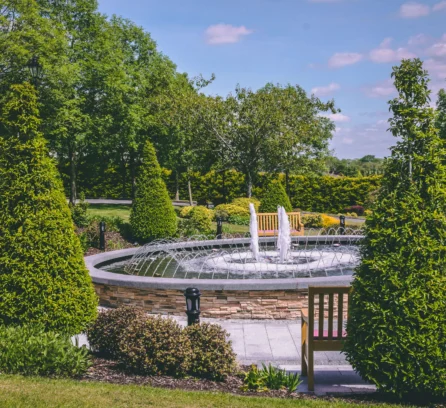 Family enjoying a sunny day by Hotel Kilmore's elegant garden fountain.