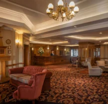 A cosy hotel lobby with elegant seating and a welcoming fireplace.