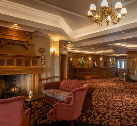 A cosy hotel lobby with elegant seating and a welcoming fireplace.