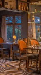 Cosy hotel restaurant with warm lighting and set tables, ready for guests.