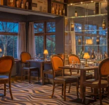 Cosy hotel restaurant with warm lighting and set tables, ready for guests.