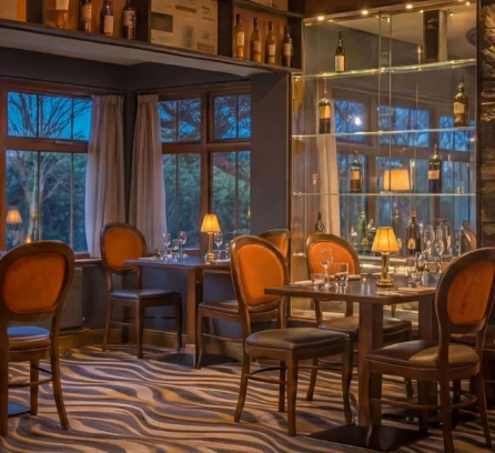 Cosy hotel restaurant with warm lighting and set tables, ready for guests.