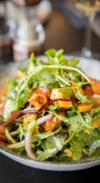 Fresh salad with mixed greens and tomatoes on a dining table at Hotel Kilmore.