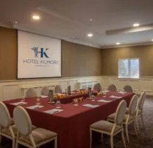 Elegant meeting room at Hotel Kilmore set for a business gathering with chairs and a projector.