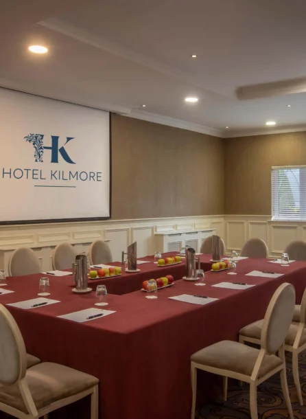 Elegant meeting room at Hotel Kilmore set for a business gathering with chairs and a projector.