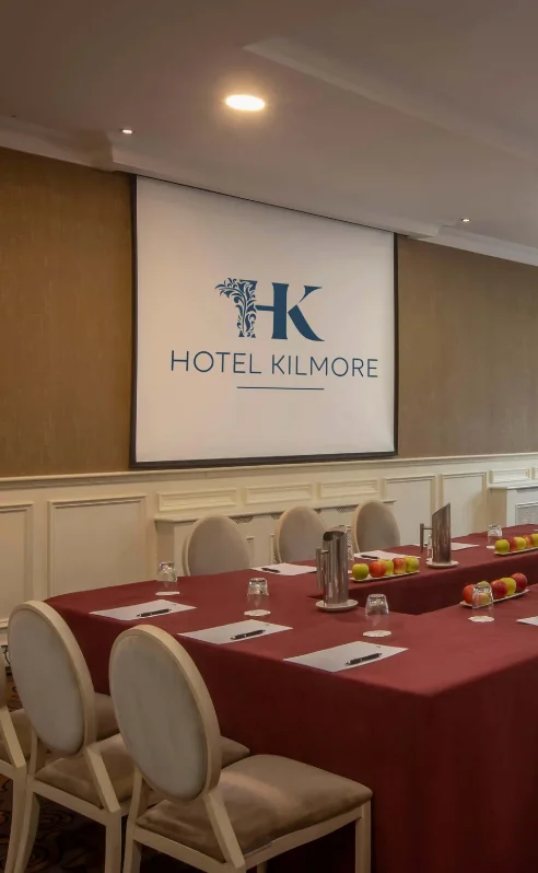 Elegant meeting room at Hotel Kilmore set for a business gathering with chairs and a projector.