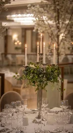 Elegant restaurant setting with candelabra and floral centrepiece on a dining table.