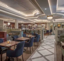 A welcoming hotel restaurant with elegant décor, set for dining, and soft ambient lighting.