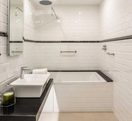 Modern bathroom with sleek white tiles and a luxury bathtub at Hotel Kilmore.