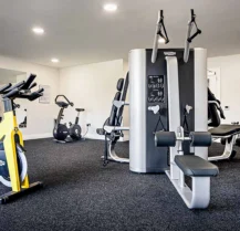 Modern gym at Hotel Kilmore with exercise bikes and multi-station fitness equipment.