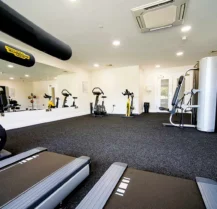 Modern hotel gym with treadmills, exercise bikes, and multi-gym equipment for guest use.