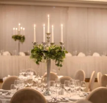 Elegant dining setup with candlelit tables in Hotel Kilmore’s banquet hall.