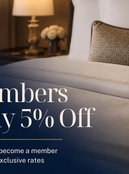 A cosy hotel room with a lamp and flowers, offering a 5% discount for members.