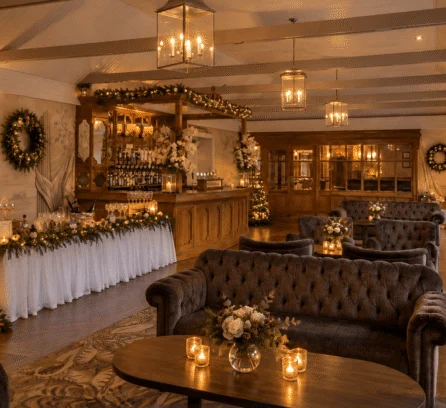 A cosy lounge in Hotel Kilmore with festive decor, inviting sofas, and a lit fireplace.