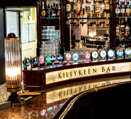 Welcoming bar area at Hotel Kilmore with a variety of drink taps and warm lighting.
